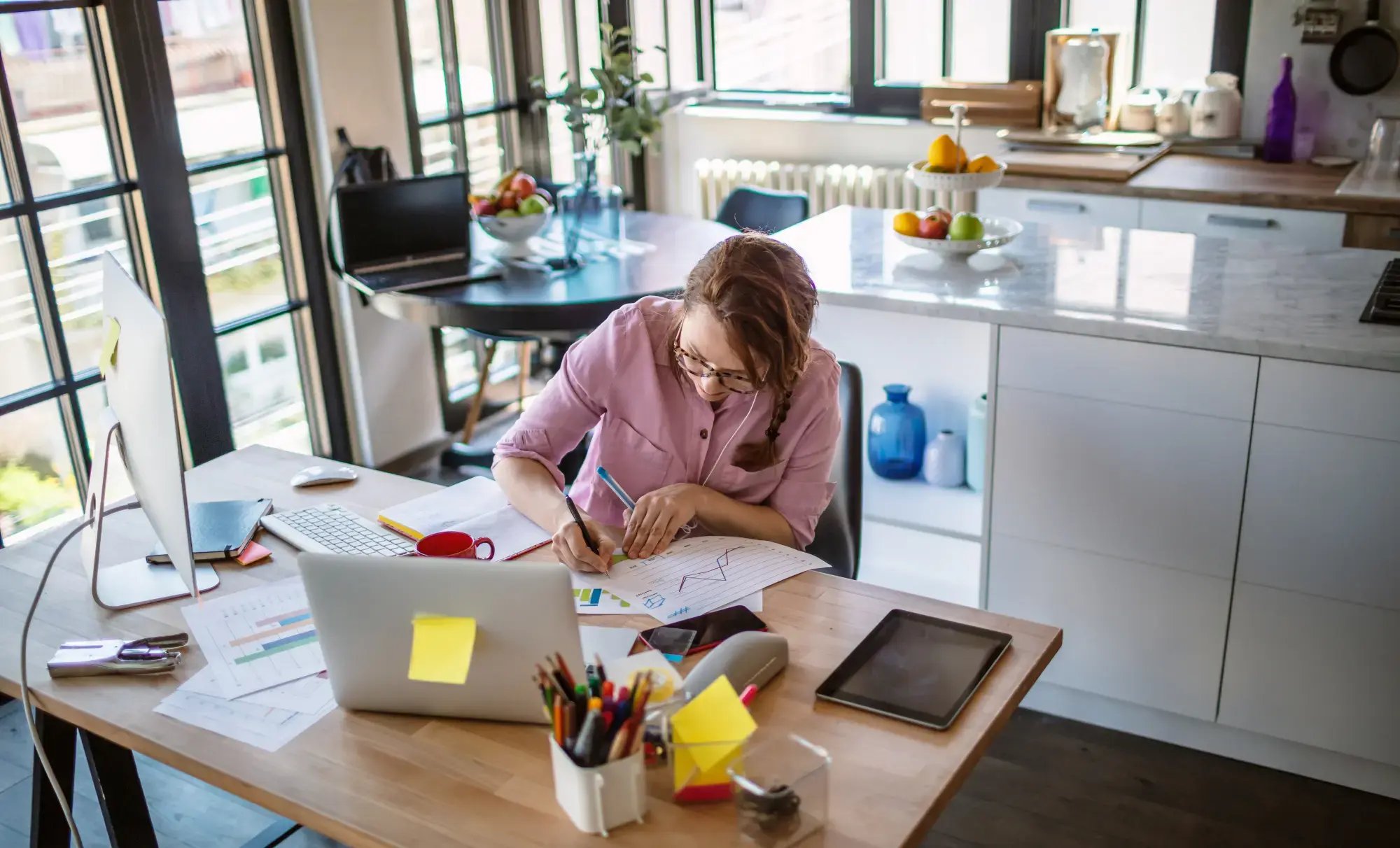 Kvinnlig företagare arbetar vid skrivbord och ska sälja faktura med eller utan regress