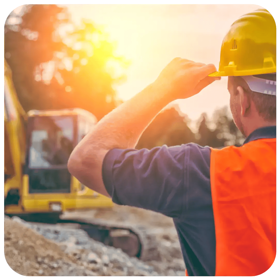 Byggare tittar på grävmaskin i morgonljuset och tänker på företagslån