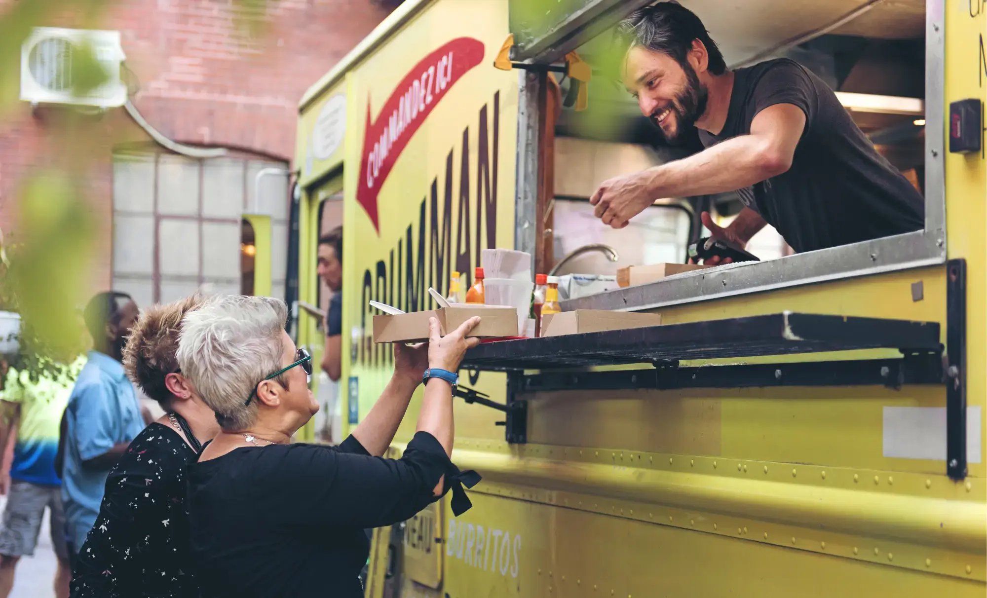 Småföretagare i Sverige gul Foodtruck säljer mat till gäster