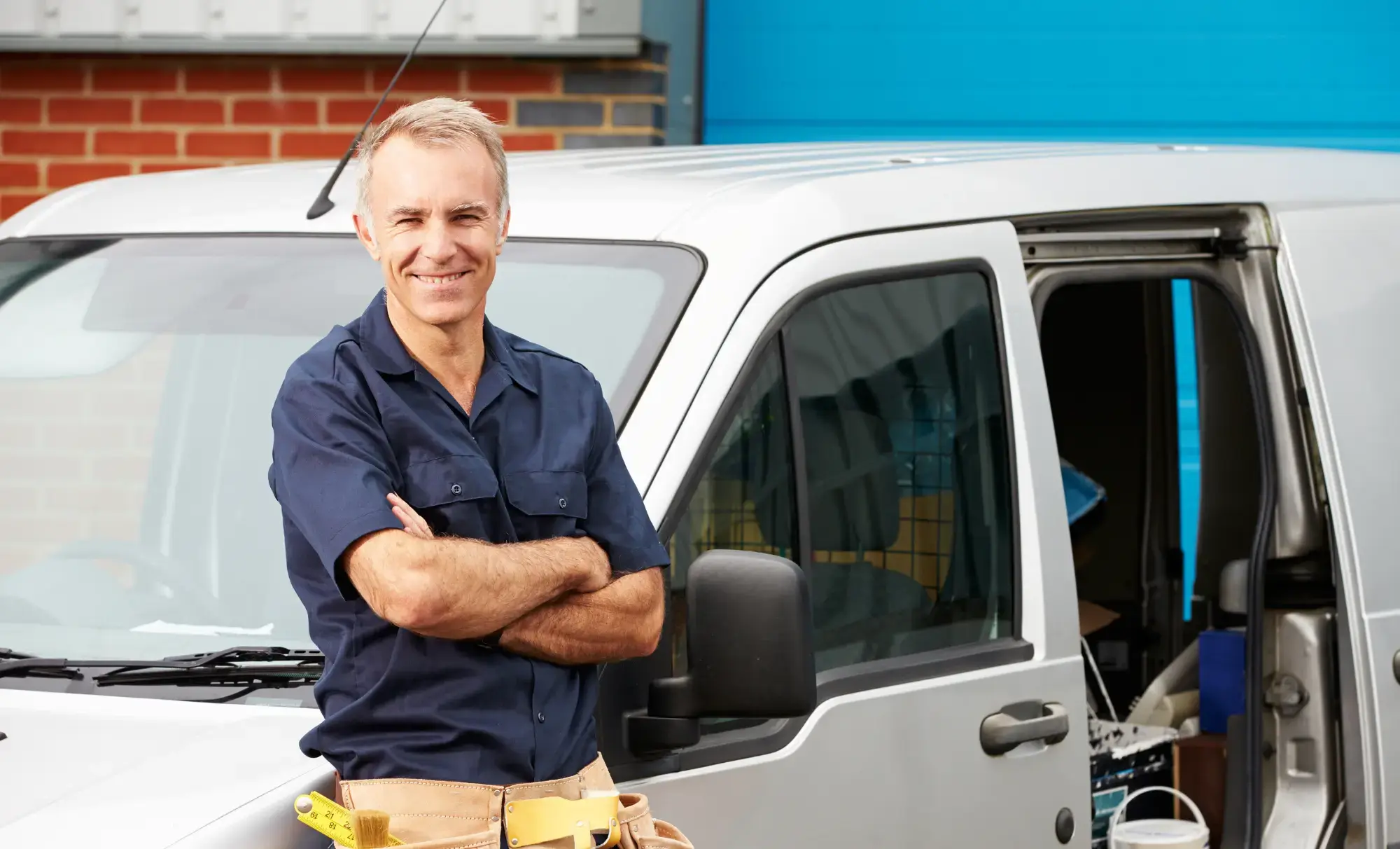 Glad företagare lutad mot företagsbil och vill veta mer om Fakturaköp med eller utan regress